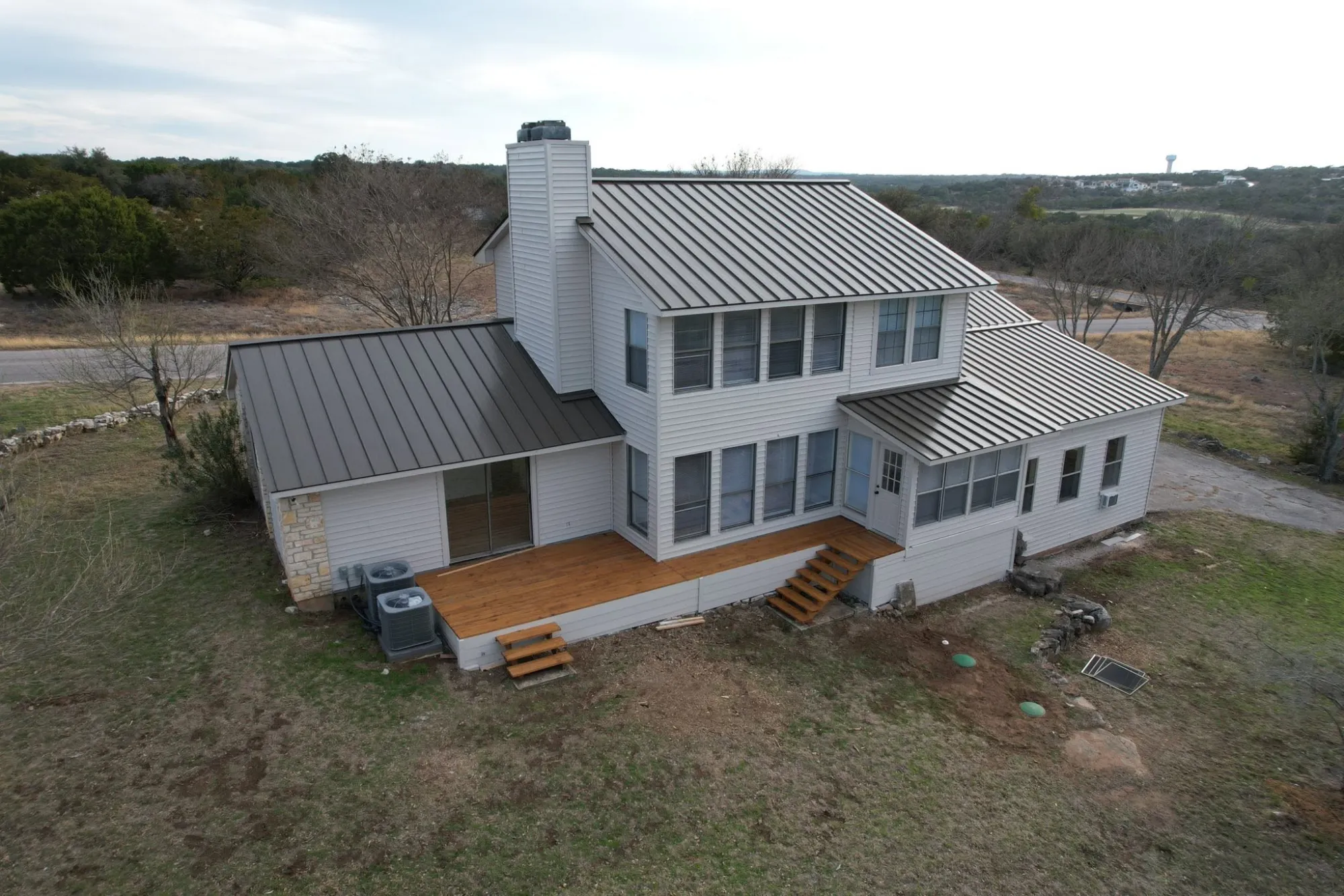 Green standing seam metal roof on a lake house